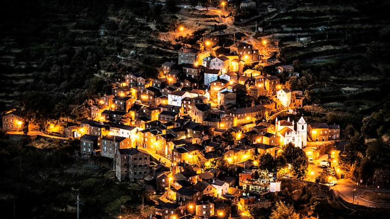Piodao (Bồ Đào Nha): Tọa lạc gần ngay công viên Serra da Estrela, Piodao được xem là một trong những ngôi làng đẹp nhất Bồ Đào Nha với những ngôi nhà chếch lên theo dốc núi. Nhà ở đây được xây bằng vật liệu có sẵn trên khu đồi xung quanh, toàn bộ cửa sổ và cửa ra vào được sơn xanh, đóng vai trò là phần không thể tách rời khỏi tổng thể kiến trúc của làng. Ảnh: The Beauty of Travel. 9 ngoi lang ben vach da ngoan muc den kho tin