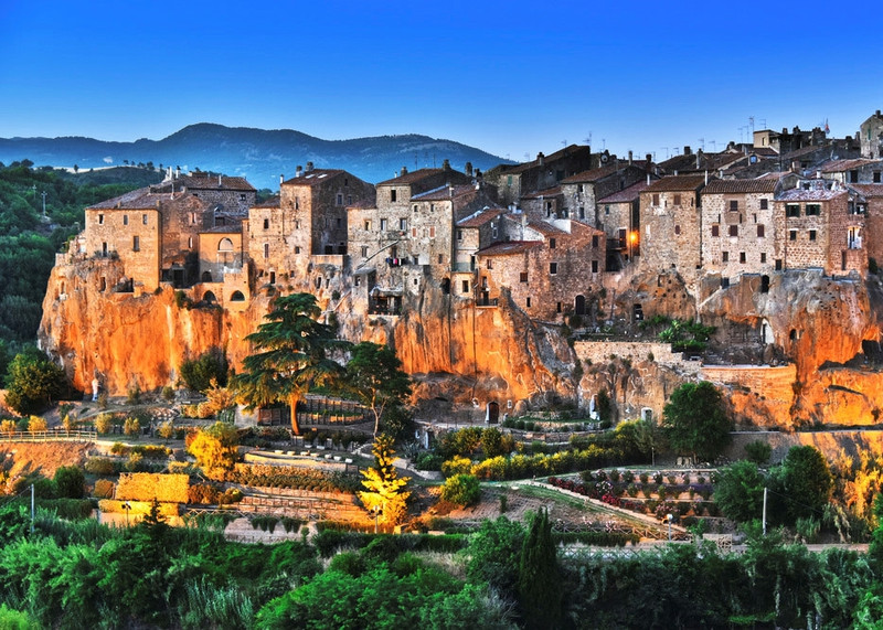 Pitigliano (Italy): Thị trấn này nằm trên đỉnh một hòn đá tufa ở độ cao hơn 300 m so với mực nước biển và thường được xuất hiện trên bưu thiếp cũng như các vật phẩm du lịch khác của Italy. Hiện nay Pitigliano có khoảng 300 ngôi nhà với dân số vào cỡ 4.000 người và chỉ có một lối ra kiêm lối vào duy nhất. Đến đây, bạn có thể bắt gặp nhiều ngôi mộ và hang động được chạm khắc từ những vách đá trong suốt nhiều thế kỉ đã được sử dụng làm hầm chứa rượu vang. Ảnh: Smarter Travel. 9 ngoi lang ben vach da ngoan muc den kho tin