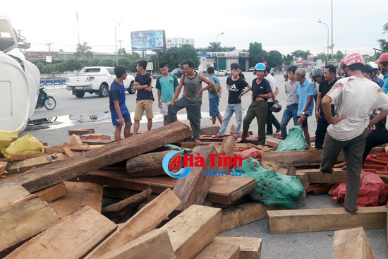 video xe container lat nghieng hang tram khuc go tung toe giua ql 1a