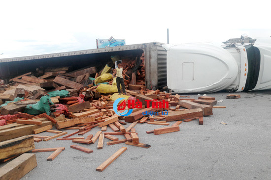 video xe container lat nghieng hang tram khuc go tung toe giua ql 1a