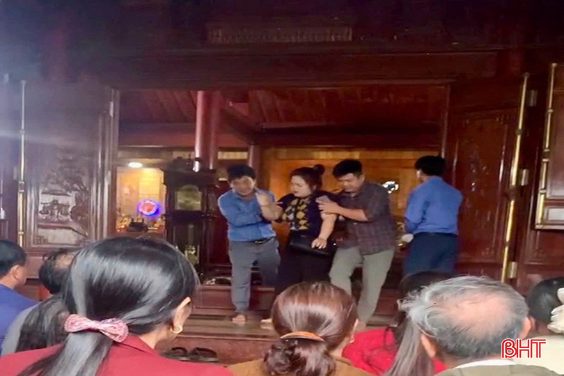 Một người phụ nữ được cho là "vong" nhập được dìu ra khỏi điện thờ.