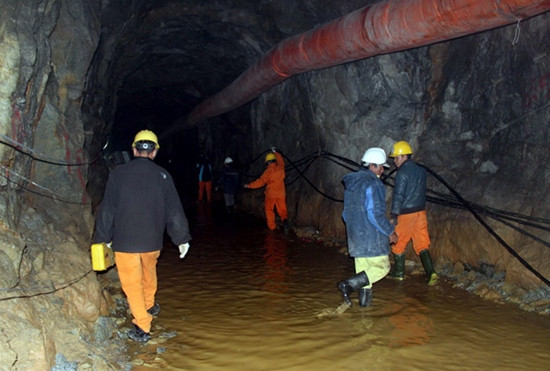 Bộ trưởng Y tế Nguyễn Thị Kim Tiến động viên chị Phan Thị Hoa - vợ anh Trương Tuấn Việt (một trong 12 người đang mắc kẹt trong hầm). Ảnh: Phước Tuấn. Nhân viên Điện lực Lâm Đồng kéo dây điện vào trong hầm để khoan hầm. Ảnh: Phước Tuấn.