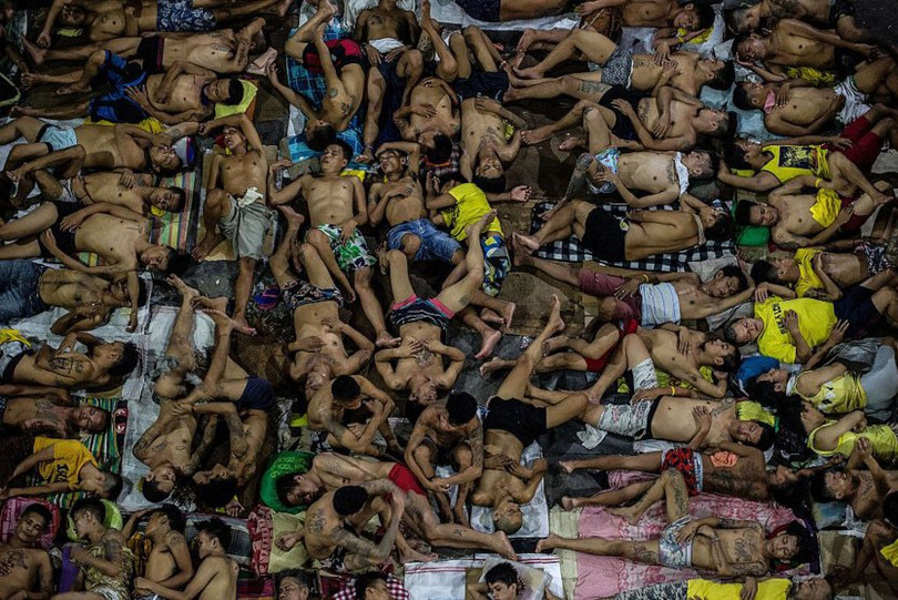 Tù nhân ngủ trên sân bóng rổ bên trong nhà tù thành phố Quezon tại Manila, Philippines, đêm 19-7. Có 3.800 tù nhân hiện đang ở tại nhà tù có sức chứa chỉ 800 người được xây dựng từ 6 thập kỷ trước - Ảnh: AFP/Getty Images su kien the gioi qua nhung buc anh noi bat nhat nam 2016