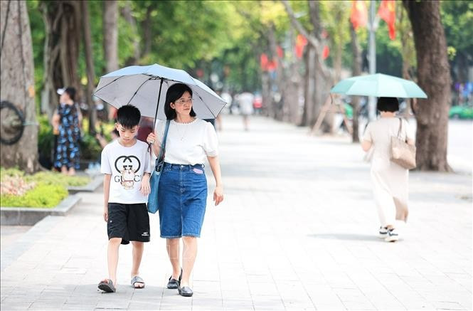 Người dân che ô khi di chuyển dưới trời nắng gay gắt. Ảnh minh họa: Lê Đông/TTXVN