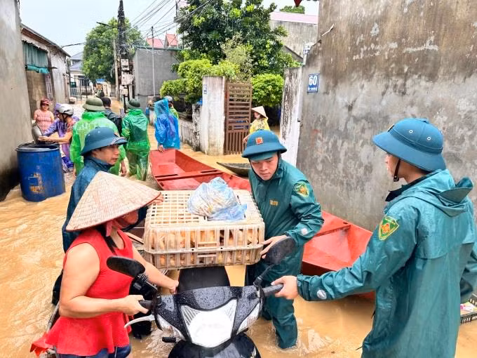 Dân quân tự vệ giúp người dân ngoại thành Hà Nội di tản đồ đạc trong đợt lũ cuối tháng 7 đầu tháng 8/2024. Ảnh: Gia Chính