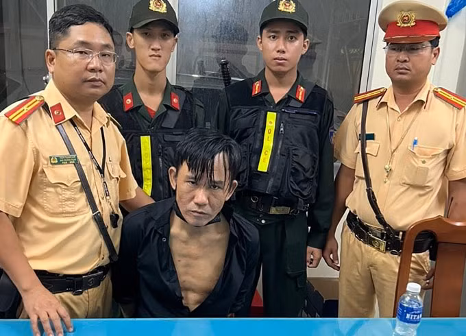 Ngô Bảo Trường (ngồi) khi bị đưa về trụ sở công an. Ảnh: Công an cung cấp