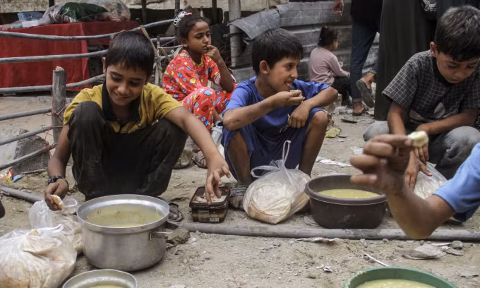 Trẻ em ở trại tị nạn Jaliaba tại miền bắc Gaza ăn thực phẩm viện trợ hôm 24/9. Ảnh: AFP