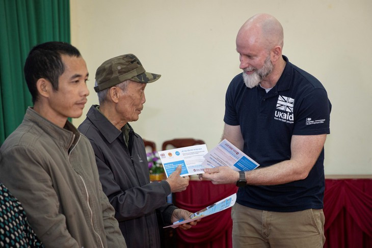 Bí thư thứ nhất phụ trách khí hậu và thiên nhiên Đại sứ quán Anh, ông Fergus McBean, trao tiền hỗ trợ cho các hộ gia đình bị ảnh hưởng bởi bão lũ năm nay tại Lạng Sơn - Ảnh: UNICEF