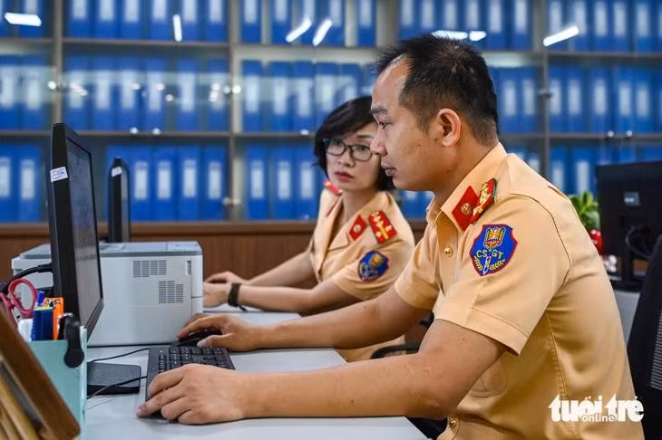 Cán bộ giám sát đấu giá biển số xe - Ảnh: HỒNG QUANG