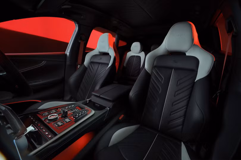 Ghế ngồi nổi bật với họa tiết xương cá đặc trưng, mở rộng dần lên trên tạo cảm giác chuyển động. Logo "S" được thêu trên tựa lưng, cùng biểu tượng Aston Martin dập chìm tinh xảo trên tựa đầu.