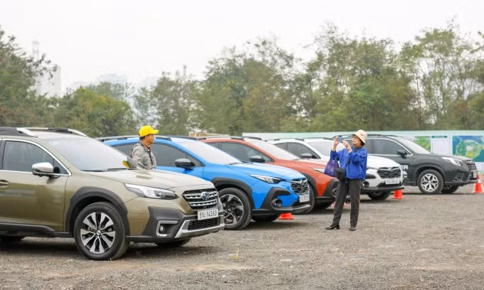 Vợ chồng cô Thoa trong số những người đến sớm nhất, đăng ký lái thử nhiều mẫu xe. Ảnh: Lương Dũng