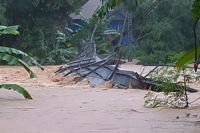 Cầu treo bắc qua sông Quàng ở xã Mường Quàng, huyện Quế Phong cũ, bị lật do nước lũ dâng cao, chiều 22/7. Ảnh: Hùng Lê Cầu treo bắc qua sông Quàng ở xã Mường Quàng, huyện Quế Phong cũ, bị lật do nước lũ dâng cao, chiều 22/7. Ảnh: Hùng Lê