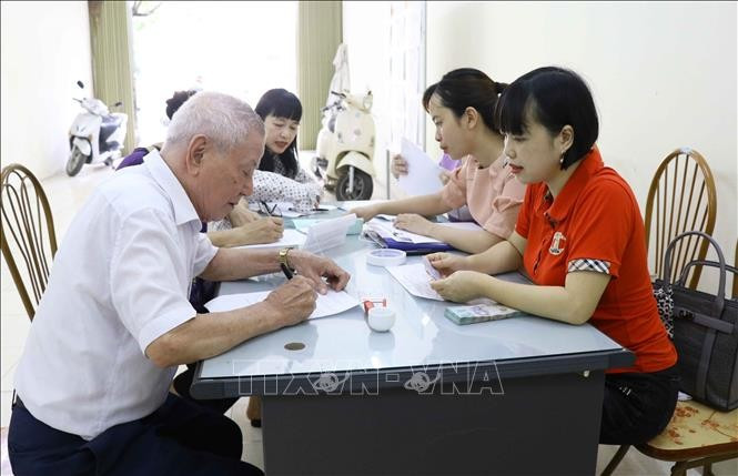 Người cao tuổi ký nhận tiền hỗ trợ từ gói an sinh xã hội. Ảnh: TTXVN Người cao tuổi ký nhận tiền hỗ trợ từ gói an sinh xã hội. Ảnh: TTXVN
