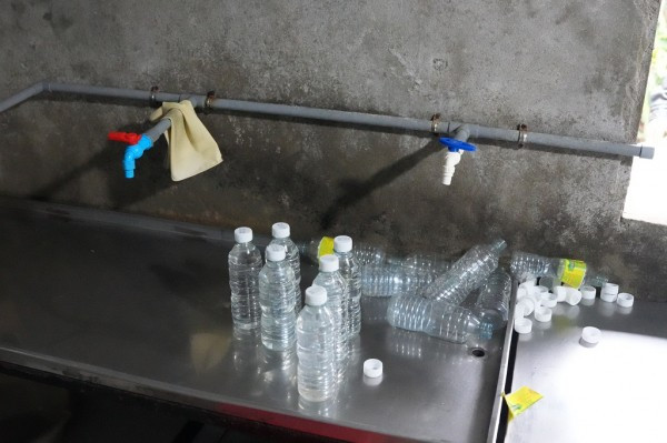 Sau khi pha chế axit acetic công nghiệp với nước lã, Lê Thị Lộc san chiết sang chai nhựa để tiêu thụ ra thị trường (Trong ảnh: Khu vực san chiết giấm giả tại cơ sở sản xuất của Lê Thị Lộc).