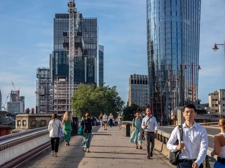 Người đi bộ băng qua một cây cầu bắc qua sông Thames ở London, Anh - Ảnh: THE NEW YORK TIMES