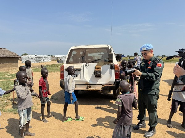 Thiếu tá Nguyễn Thế Anh chụp ảnh và trò chuyện với trẻ em ở Nam Sudan trên đường làm nhiệm vụ. Thiếu tá Nguyễn Thế Anh chụp ảnh và trò chuyện với trẻ em ở Nam Sudan trên đường làm nhiệm vụ.
