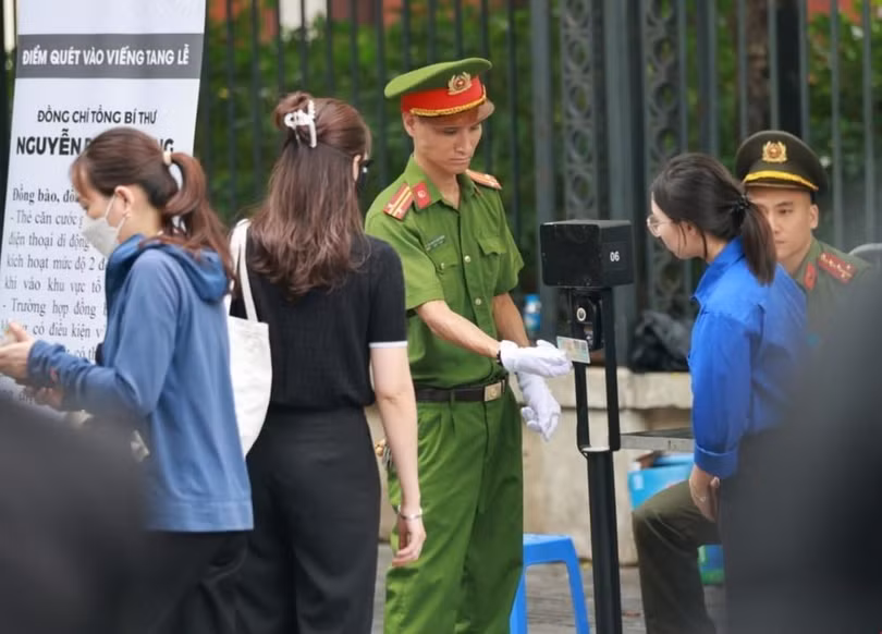 Lực lượng an ninh quét mã QR trên căn cước của người dân vào viếng Tổng Bí thư tại Nhà tang lễ Quốc gia. (Ảnh: TTXVN)