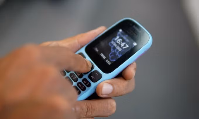Một người đang dùng một điện thoại 2G, sẽ bị vô hiệu hóa từ 15/10. Ảnh: Lưu Quý