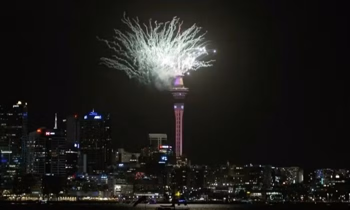 Auckland (New Zealand) là thành phố lớn đầu tiên chào đón năm 2025. Hàng nghìn người đã tham gia đếm ngược và reo hò trước màn bắn pháo hoa đầy màu sắc từ tòa tháp mang tính biểu tượng Sky Tower. Ảnh: Reuters.