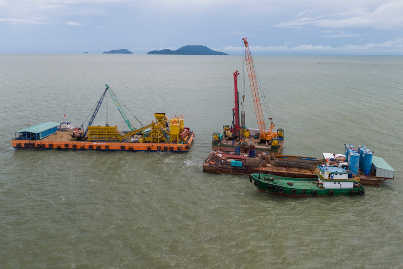 Cách đó không xa, đội ngũ kỹ sư - công nhân đang tiến hành đổ bê tông nhồi cọc dưới điều kiện thời tiết phức tạp và thủy triều thay đổi liên tục.