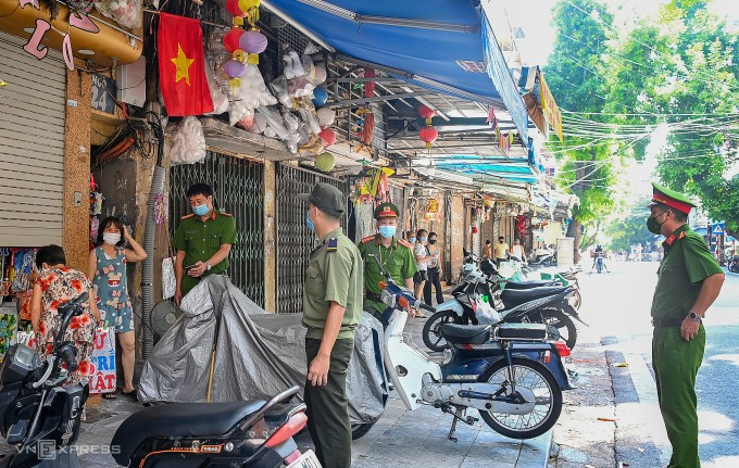 Công an phường tại Hà Nội nhắc nhở các cửa hàng trong thời gian giãn cách dịch Covid-19. Ảnh: Giang Huy Công an phường tại Hà Nội nhắc nhở các cửa hàng trong thời gian giãn cách dịch Covid-19. Ảnh: Giang Huy
