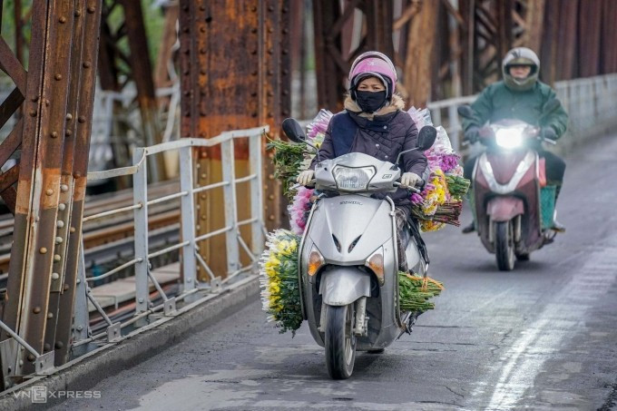 Người dân di chuyển qua cầu Long Biên, bắc qua sông Hồng, trong tiết trời lạnh khô tháng 3/2025. Ảnh: Hoàng Giang