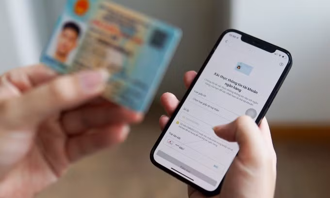 Một người đang thực hiện xác minh danh tính eKYC bằng Căn cước công dân trên một ứng dụng điện thoại. Ảnh: Lưu Quý