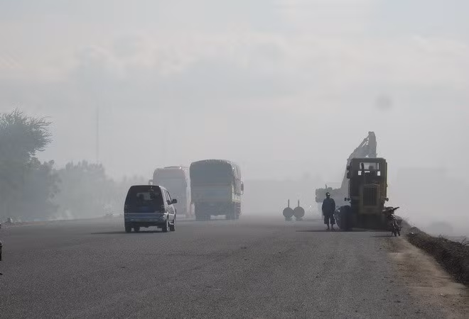 Các phương tiện tham gia giao thông trong khói bụi. (Nguồn ảnh: TTXVN)