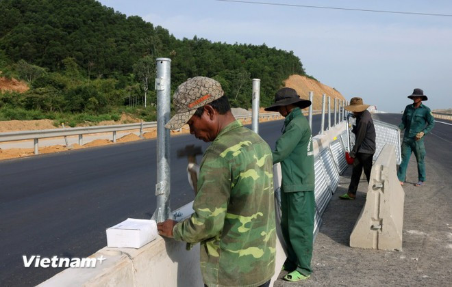 Công nhân lắp đặt dải phân cách và lưới chống chói tại Dự án cao tốc Quảng Ngãi-Hoài Nhơn. (Ảnh: Quốc Khánh/Vietnam+) Công nhân lắp đặt dải phân cách và lưới chống chói tại Dự án cao tốc Quảng Ngãi-Hoài Nhơn. (Ảnh: Quốc Khánh/Vietnam+)