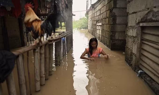 Người phụ nữ lội qua con hẻm ngập nước ở khu vực phía bắc Manila, Philippines ngày 4/9. Ảnh: Reuters