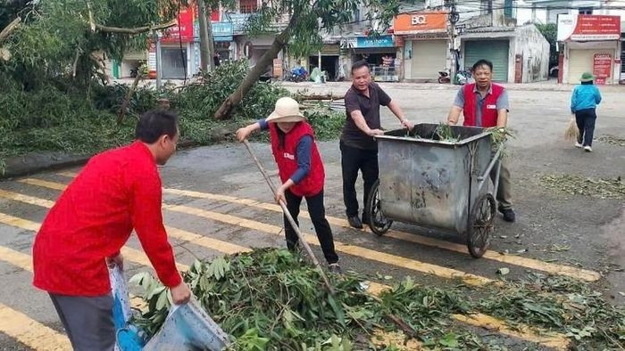 Các cán bộ, tình nguyện viên Hội Chữ thập đỏ tỉnh Hà Tĩnh hỗ trợ người dân thu dọn sau bão số 5.