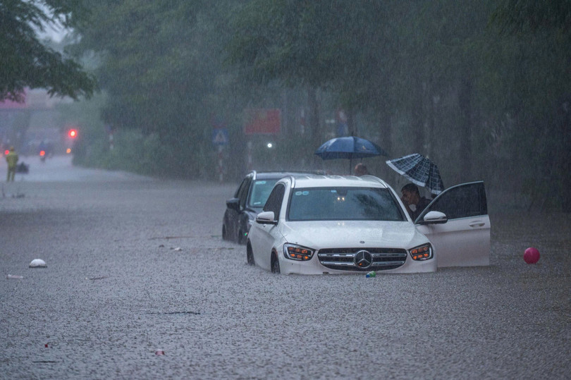 Chiếc Mercedes-Benz E-Class &quot;bất lực&quot;, không thể di chuyển giữa con đường ngập nước và phải gọi cứu hộ trên phố Thái Hà. Ảnh: Việt Hà.