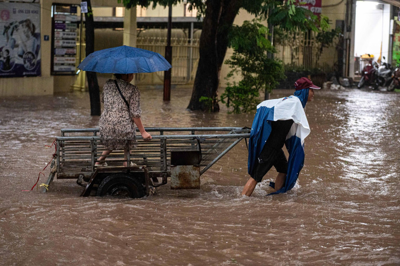 Ở đường Láng Hạ lúc 8h, một số người dân phải nhờ tới sự hỗ trợ của xe kéo để vượt qua điểm ngập. Ảnh: Việt Hà.