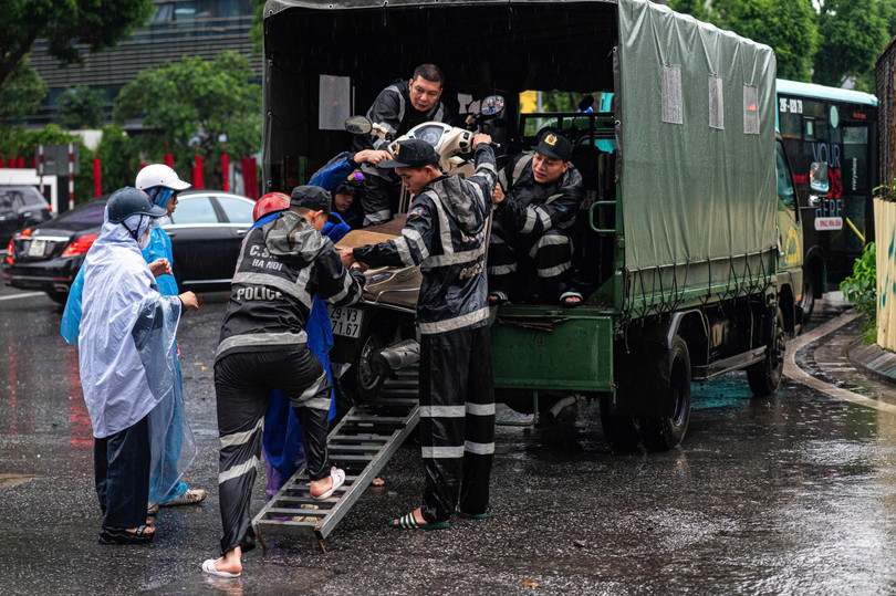 Ghi nhận tại ngã tư Liễu Giai - Đào Tấn, lực lượng CSCĐ phải sử dụng xe chuyên dụng để hỗ trợ người dân di chuyển xe máy ra khỏi điểm ngập úng. Ảnh: Việt Hà.