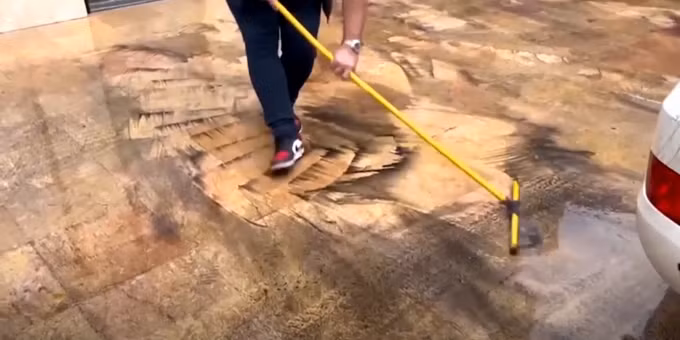 Nhân viên vệ sinh lau vết dầu sau cơn mưa trước cửa văn phòng WHO tại Tehran, ngày 8/3. Ảnh: Reuters