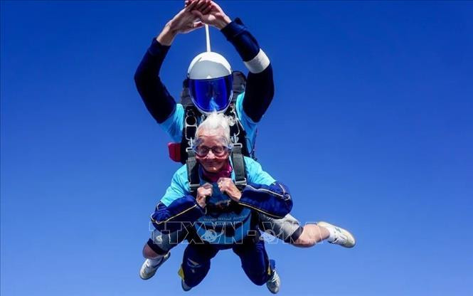 Dưới sự hỗ trợ của một trợ lý, cụ bà Manette Baillie thực hiện thành công cú nhảy dù ngoạn mục từ độ cao hơn 2.100 m, ngày 25/8/2024. Ảnh: The Telegraph/TTXVN