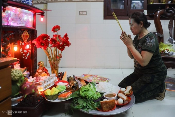 Người dân thực hiện nghi lễ cúng Thần tài. Ảnh: Quỳnh Trần