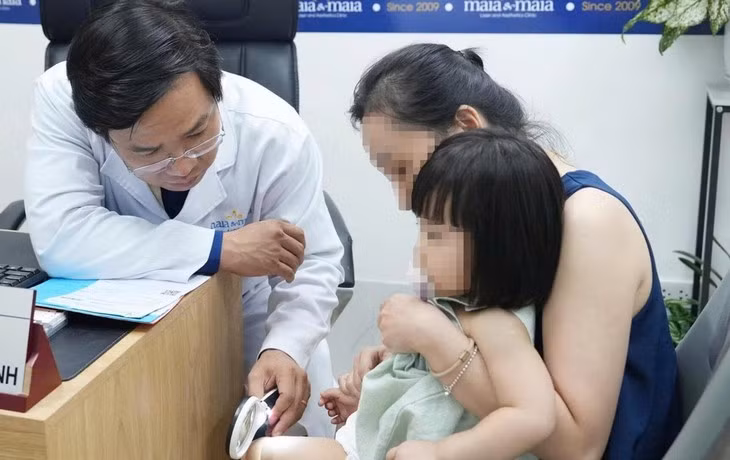 Bác sĩ Nguyễn Tiến Thành khám cho một em bé - Ảnh: DƯƠNG LIỄU