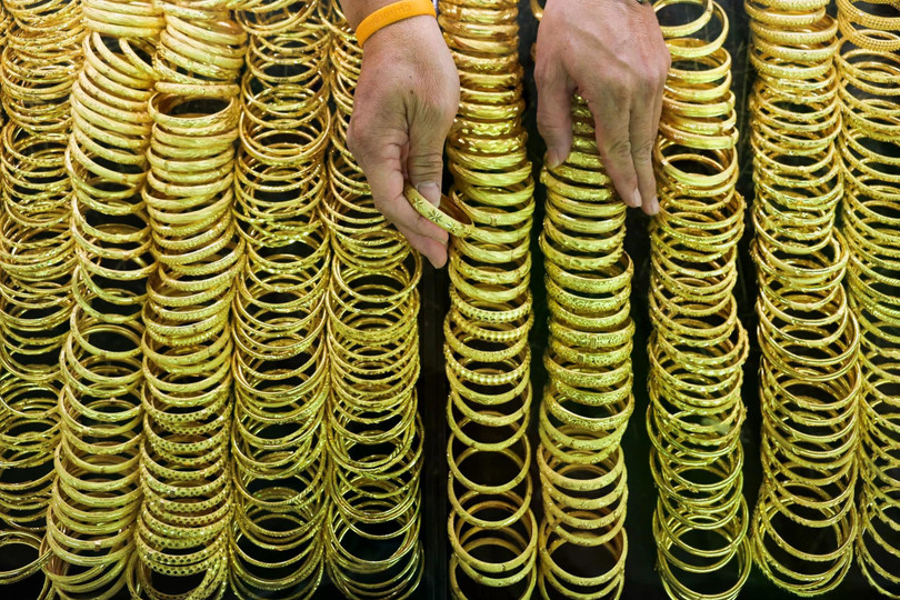 Một người bán vàng sắp xếp vòng tay vàng tại cửa hàng vàng trước Tết Nguyên đán tại khu phố Chinatown của Bangkok, Thái Lan.