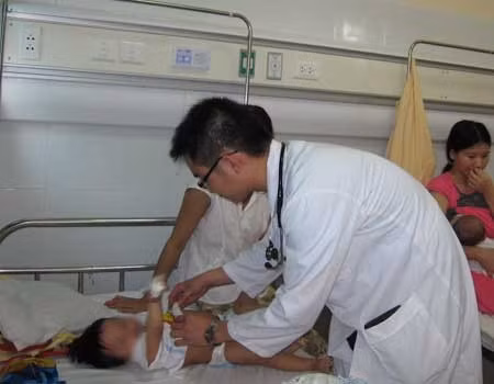 Bác sĩ Tuấn đang khám cho một bệnh nhi bị viêm não. Ảnh: P.N.