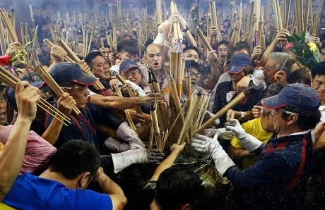 Người dân chen nhau cắm nhang tại chùa Kwan Im Thong Hood Cho ở Singapore trong ngày đầu năm. Họ mong rằng nghi lễ này sẽ mở màn cho một năm đầy thuận lợi trong công việc, đem lại sự bình an cho gia đình. (Ảnh: RT)