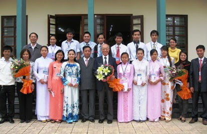 Ngài Watanabe (người đứng giữa ôm bó hoa) cùng lãnh đạo Trường ĐH Vinh chụp ảnh lưu niệm với các sinh viên được nhận học bổng.