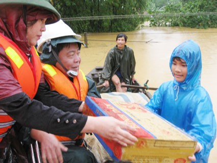 Chủ tịch UBND tỉnh Võ Kim Cự và Trưởng Ban Dân vận Tỉnh ủy Trần Thị Kim Hoa trao hàng cứu trợ cho người dân vùng lũ