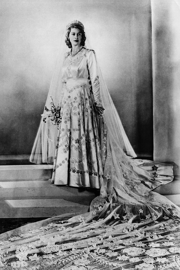 Nữ hoàng Anh Elizabeth II, 1947: Tháng 11 năm 1947, Nữ hoàng Elizabeth II kết hôn với Hoàng tử Philip khi Thế chiến II kết thúc được 2 năm. Theo BBC, váy cưới được thiết kế bởi Norman Hartnell, làm từ chất liệu lụa màu ngà, đính 10.000 viên ngọc trai, họa tiết trên thân áo thêu tay bằng những sợi chỉ tơ ánh bạc. Bà đội vương miện kim cương được truyền lại từ Nữ hoàng Elizabeth I. 14 mau vay cuoi dep nhat trong lich su hoang gia cac nuoc