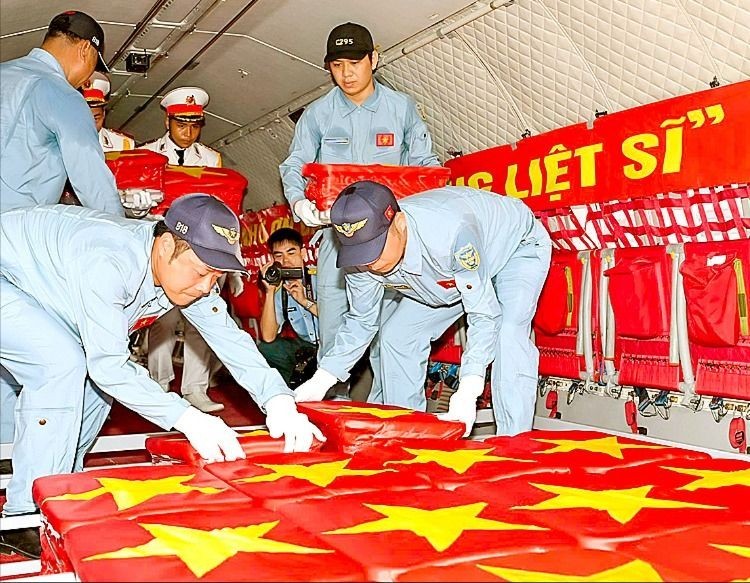 Cán bộ, chiến sĩ trang trọng đặt các mẫu sinh phẩm hài cốt liệt sĩ lên máy bay tại sân bay Tân Sơn Nhất. Ảnh: MẠNH THẮNG