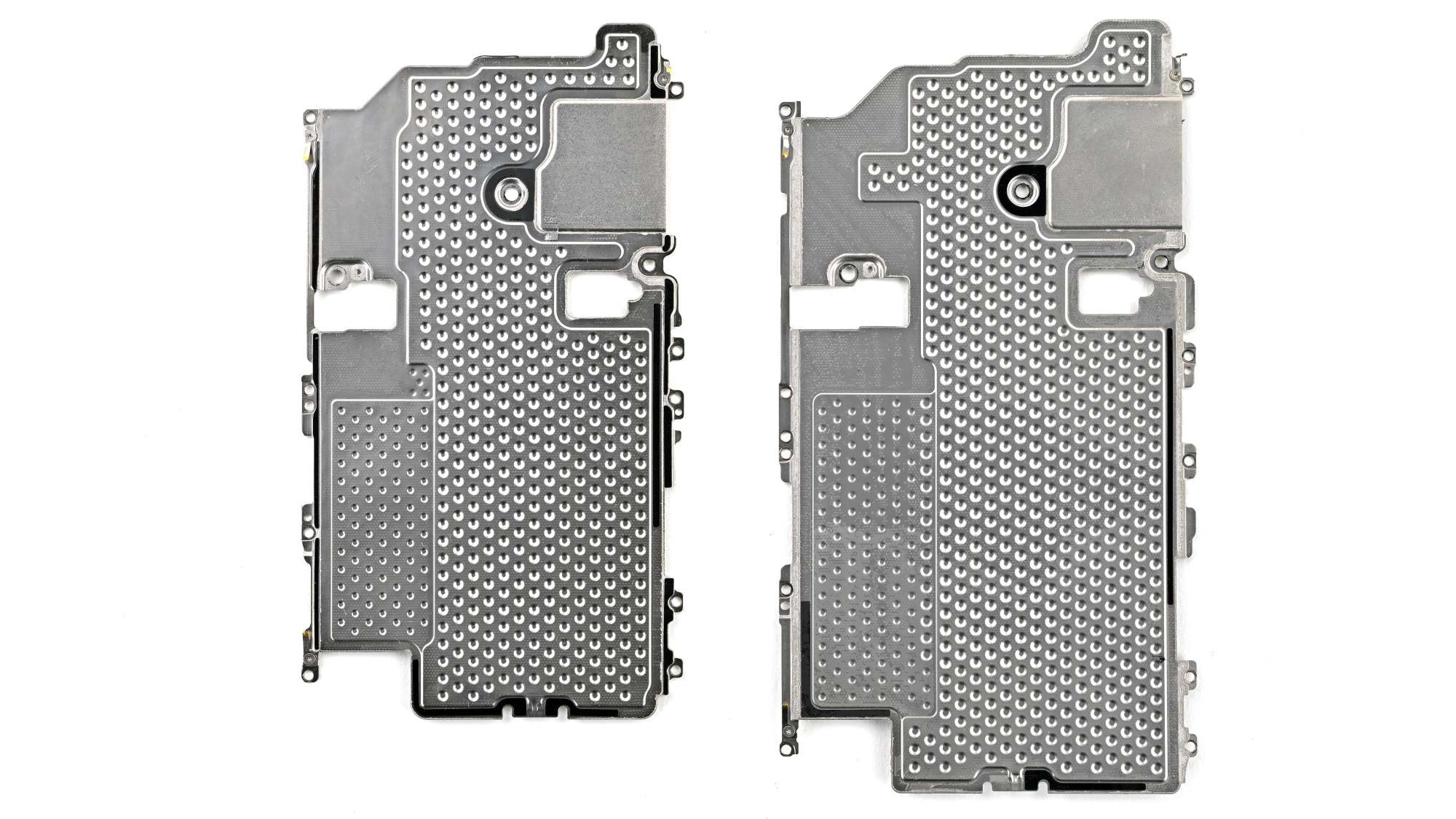 Viên pin dung lượng lớn trên máy (bên trái là của iPhone 18 Pro, bên phải là Pro Max) được đặt gọn bên trong một khay kim loại cố định bằng các định vị ốc vít. Thiết kế này tiếp tục kế thừa ưu điểm giúp bảo vệ pin an toàn hơn. Lớp keo dán pin vẫn sử dụng công nghệ giải phóng bằng dòng điện hạ áp, cho phép tháo viên pin ra khỏi khay chỉ sau khoảng 90 giây kích điện. Ở trong ảnh, lớp phía dưới là tản nhiệt buồng hơi mới, với kích cỡ lớn hơn hẳn so với mẫu iPhone 17 Pro Max. Ảnh: iFixit.