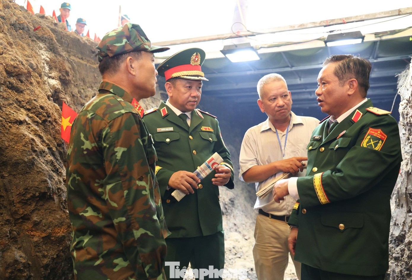 Thiếu tướng Trần Chí Tâm (đầu tiên, từ phải sang) cùng Thiếu tướng Nguyễn Thành Trung (thứ 3 từ phải sang), Chính ủy Bộ Tư lệnh TPHCM, kiểm tra, chỉ đạo tại khu vực khai quật hài cốt liệt sĩ trong công viên Lê Thị Riêng. Ảnh: Ngô Tùng/Tiền Phong.