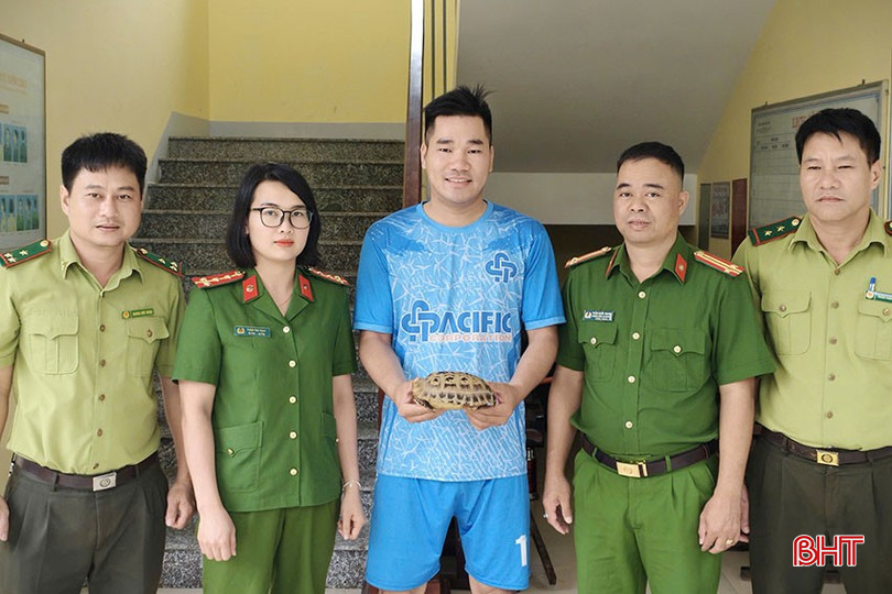 Mr. Bui Duc Nhat (middle) handed over the golden turtle to the authorities to release it back into the wild. bqbht_br_2.jpg