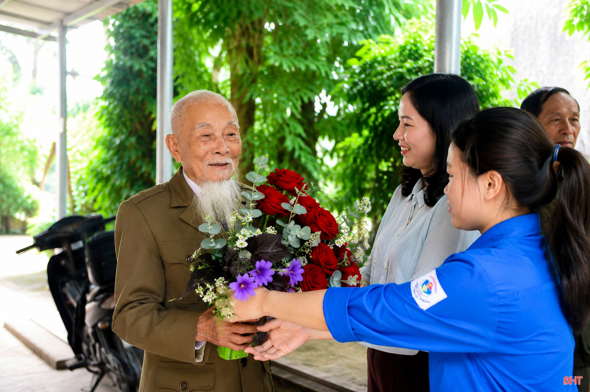 Lãnh đạo địa phương, ĐVTN tặng hoa cho cựu binh Phan Văn Thi, nhân chuyến đến thăm và nghe ông ôn lại truyền thống lịch sử.