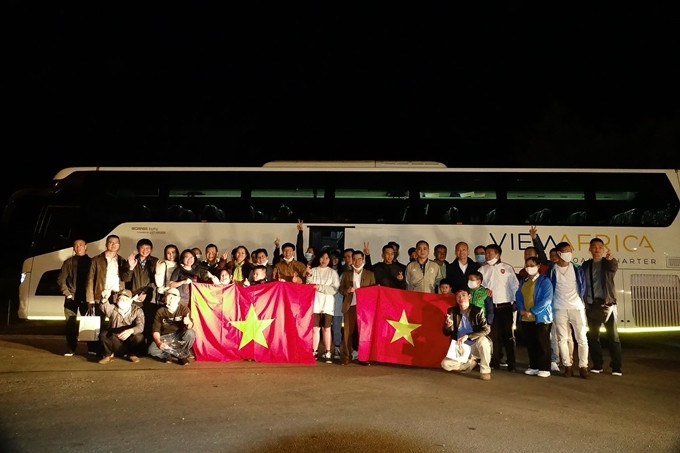 Đoàn Việt Nam chụp ảnh kỷ niệm tại biên giới Mozambique và Nam Phi, tạm biệt các nhân viên Đại sứ quán. Phượt thủ Việt vòng quanh thế giới phải hồi hương vì Covid-19